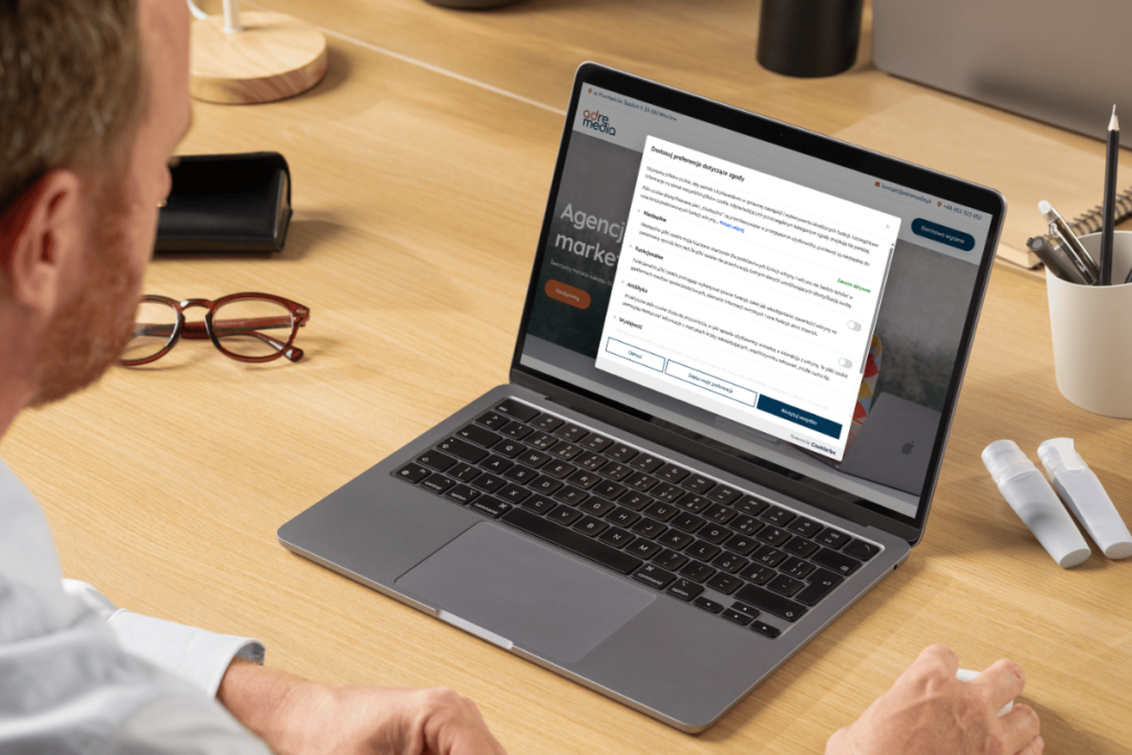 Mężczyzna korzystający z laptopa z widocznym banerem zgód cookies – symbol wdrożenia Consent Mode v2 i zarządzania zgodami użytkowników.