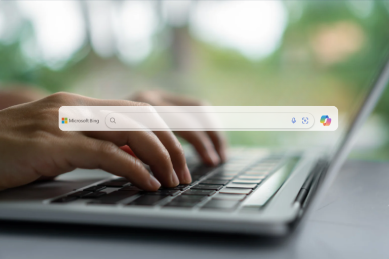 Ręce piszące na klawiaturze laptopa z otwartą wyszukiwarką Microsoft Bing – symbol kampanii reklamowych w ekosystemie Microsoft Ads.